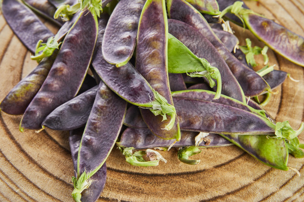 2400-purple-peas-lie-in-slide-on-wooden-board-on-gray-concrete