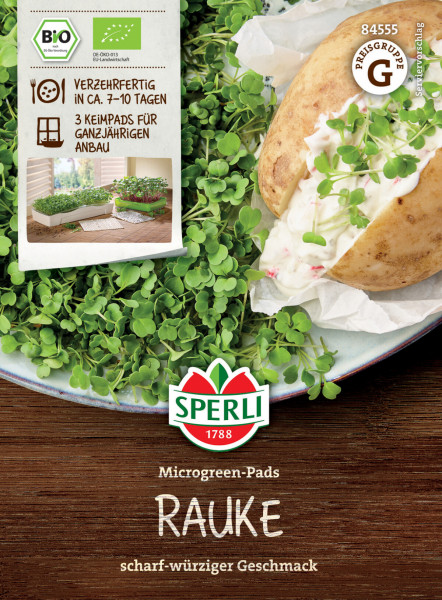 Produktbild von Sperli BIO Microgreen-Pads Rauke mit Verpackung und einer geöffneten Kartoffel belegt mit Keimlingen auf einem Teller neben weiteren Keimlingen auf einer Holzoberfläche.