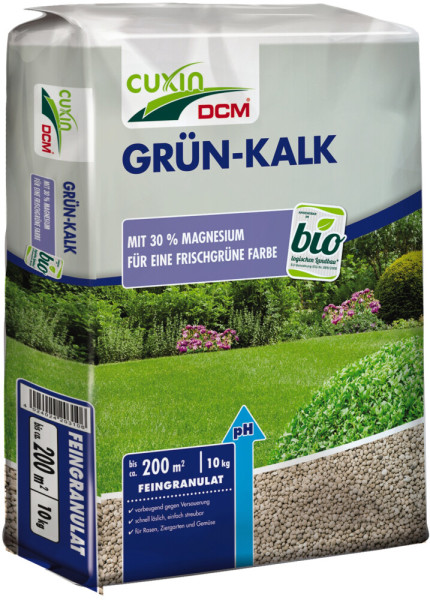 Produktbild von Cuxin DCM Grün-Kalk Feingranulat 10kg Verpackung mit Informationen zu Inhaltsstoffen und Anwendungshinweisen auf einem Hintergrund mit grünem Rasen und Pflanzen.