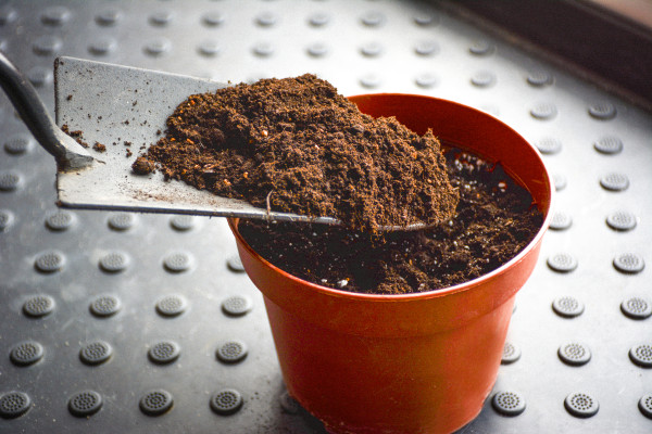 large-a-flower-pot-filled-with-dark-soil-a-small-flower-pot-and-a-shovel-with-fertile-earth-ready-for-planting-gardening-concept