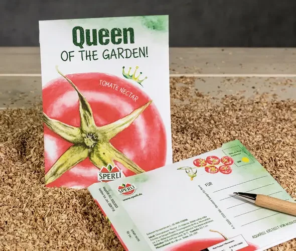 Produktbild einer Sperli Saatgut Postkarte mit der Illustration einer Tomate Nectar und der Aufschrift Queen of the Garden neben einem Bleistift und Anweisungen zur Aussaat.