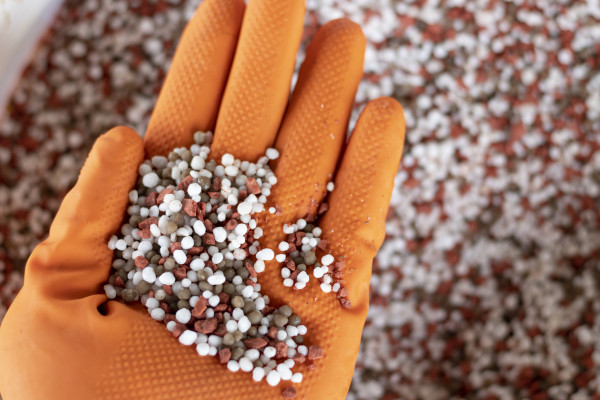 2400-chemical-fertilizer-at-the-hands-of-farmers-with-nature-background